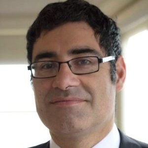 Descripción: Un abogado de familia con gafas vistiendo un traje y corbata.