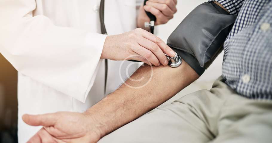 Un médico mide cuidadosamente la presión arterial de un paciente.