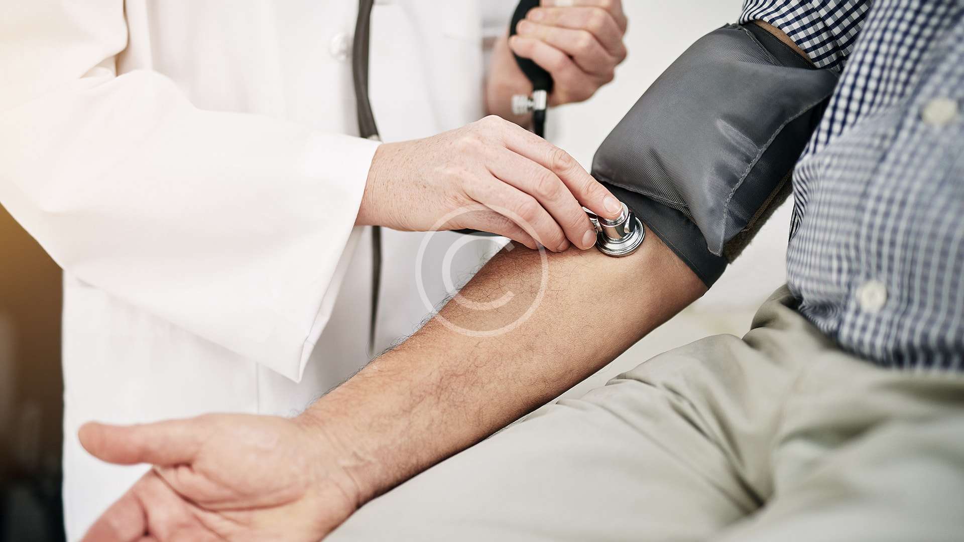 Un médico mide cuidadosamente la presión arterial de un paciente.