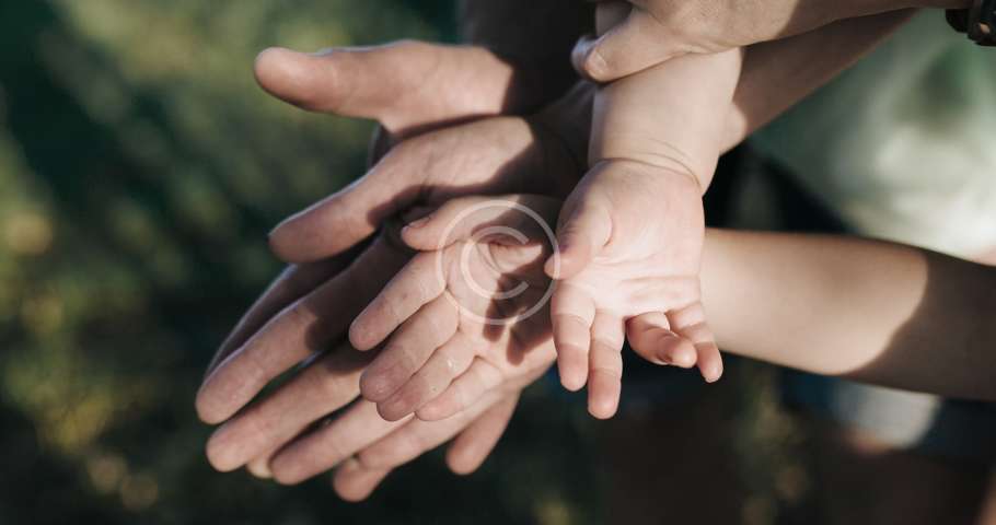 El abogado de familia y sus clientes, unidos y apoyándose mutuamente al entrelazar sus manos.