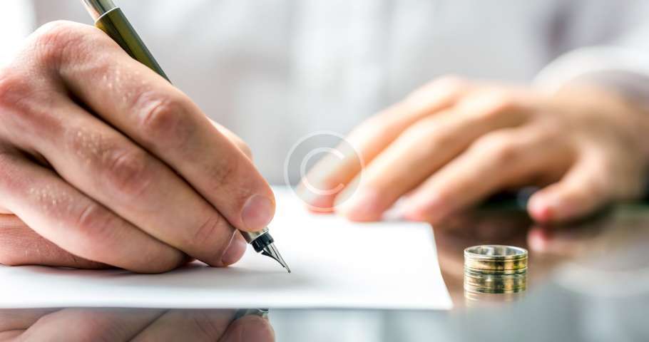 Un abogado de familia firma un documento con un anillo de matrimonio.